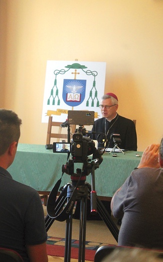 W trakcie spotkania nowemu gospodarzowi diecezji towarzyszył herb z zawołaniem: „Deus caritas est”, czyli „Bóg jest miłością”.