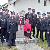 Strażacy OSP przy pamiątkowym obiekcie.