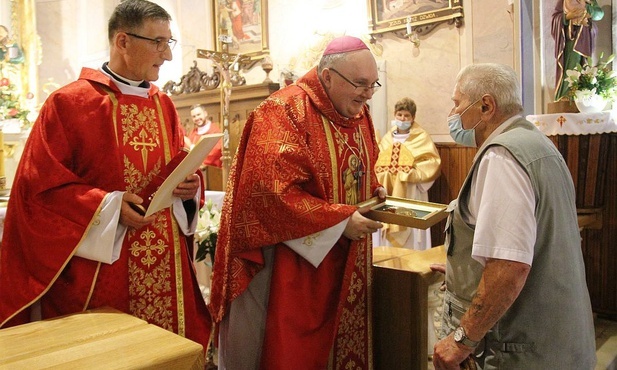 Stanisław Duszczyński odbiera Muszlę św. Jakuba z rąk bpa Janusza Mastalskiego i ks. proboszcza Krzysztofa Moskala.