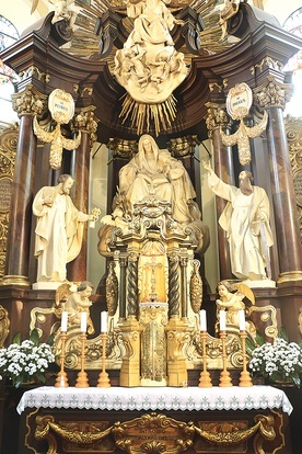 ▲	W głównym ołtarzu wyobrażona jest patronka parafii w towarzystwie Matki Bożej oraz świętych Piotra i Pawła.
