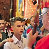 Pasterz archidiecezji udziela sakramentu inicjacji chrześcijańskiej.