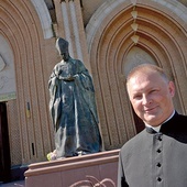 Ksiądz Marcin Rogala przy pomniku Prymasa Tysiąclecia, który stoi przed radomską katedrą.