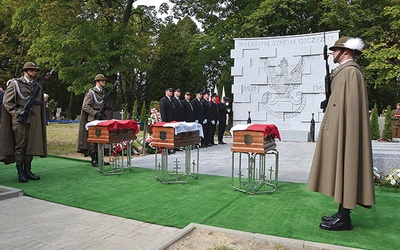 ▲	Trumny bohaterów przed granitową ścianą z wizerunkiem przedwojennego orła wojskowego.