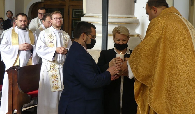 Katarzyna i Radomił Pudełkowie z Chybia odbierają oazową święcę dla pary rejonu cieszyńskiego z rąk ks. Jacka Moskala.