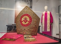 	Wśród eksponatów jest zdobiona infuła, liturgiczne nakrycie głowy biskupa, wykonana najprawdopodobniej z okazji wyboru papieża Jana XXIII.