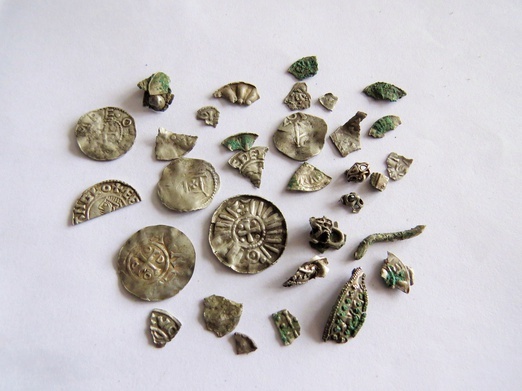 Monety i fragmenty ozdób odkryte podczas badań sondażowych.