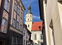 ▲	Świątynia z jednej strony jest otoczona wąskimi uliczkami wiodącymi na pszczyński rynek. Z drugiej strony rozciąga się kompleks słynnych ogrodów.