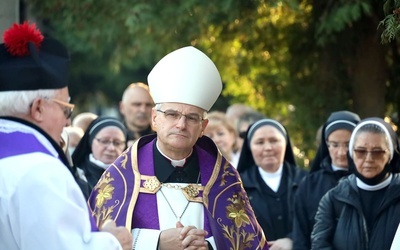 Biskup w czasie procesji z modlitwą różańcową między grobami.