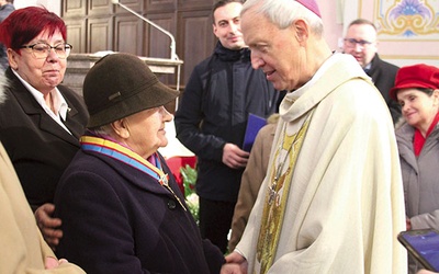 Biskup płocki w rozmowie z uhonorowaną Orderem św. Zygmunta Martą Dąbrowską i innymi członkami wspólnoty.