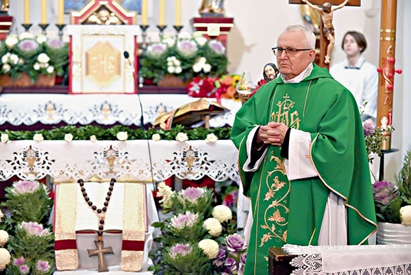 Jubilat w czasie przyjmowania życzeń na tle okolicznościowej dekoracji.