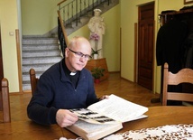 Ks. Jarosław Wojtkun przegląda kronikę parafialną.