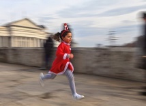 Dziewczynka w świątecznym stroju biegnie przez kamienny most w Skopje.
26.12.2021   Macedonia Północna