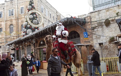 Przebrany za Mikołaja chrześcijanin zachęca przechodniów do noszenia maseczek przeciwcovidowych.
23.12.2021  Stare Miasto, Jerozolima.