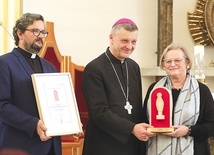 	Lidia Greń-Wajdzik odbiera nagrodę z rąk bp. Romana Pindla i ks. Piotra Hoffmanna.