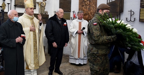 Po Mszy św. biskup wraz z (od lewej): prof. Jerzym Grzywaczem oraz kmdr. Romanem Rakowskim złożyli kwiaty przy nowo odsłoniętej i poświęconej tablicy ku czci poległych i zmarłych żołnierzy wszystkich formacji Armii Krajowej.