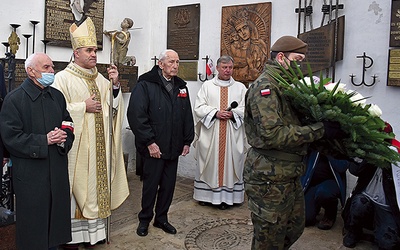 	Po Mszy św. biskup wraz z prof. Jerzym Grzywaczem (z lewej) oraz kmdr. Romanem Rakowskim złożyli kwiaty przy nowo odsłoniętej i poświęconej tablicy ku czci poległych i zmarłych żołnierzy.