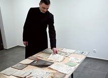 	Ksiądz Sebastian Kapuściński prezentuje część odnalezionych zbiorów.