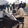 Sycylijski pianista gra na fortepianie na granicy w Medyce
