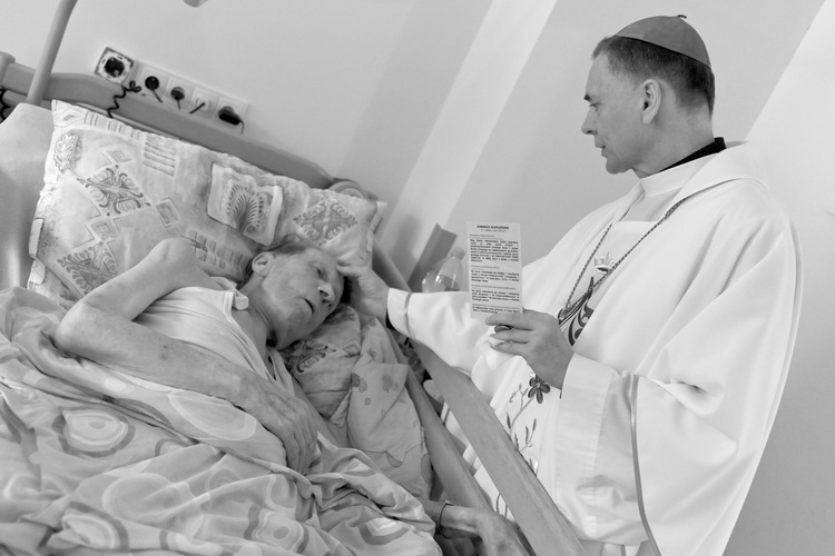 Bp Adam Bałabuch namaszczający przebywajacego w hospicjum kapłana.