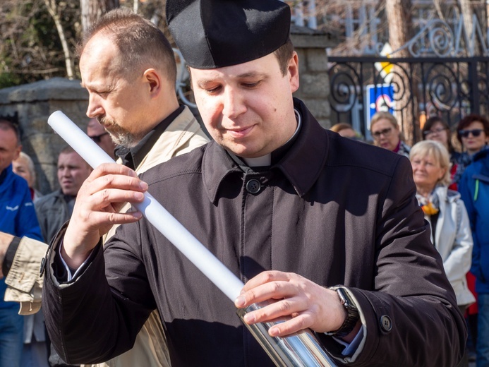 Proboszcz wkładający do kapsuły jeden z dokumentów.