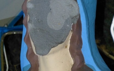 Zniszczona twarz figury Matki Bożej na placu przy kościele w Lewniowej.