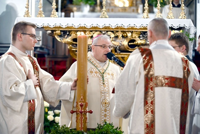 Biskup z asystą diakonów przy poświęceniu wody.