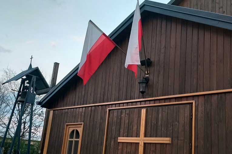 Polskie flagi przed wejściem do kościoła parafii pw. Chrystusa Kapłana znajdującego się na placu Wyższego Seminarium Duchownego w Radomiu.