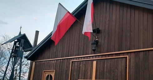 Polskie flagi przed wejściem do kościoła parafii pw. Chrystusa Kapłana znajdującego się na placu Wyższego Seminarium Duchownego w Radomiu.