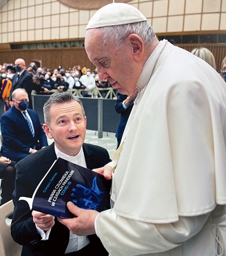 ▲	Autor prezentuje swoją książkę papieżowi Franciszkowi.
