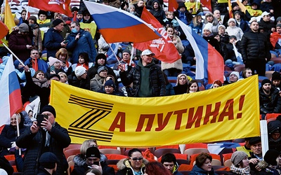 Demonstracja wsparcia dla wojny na Ukrainie.Stadion Łużniki, Moskwa, 18 marca 2022 r.  Na transparencie wykorzystany został znak „Z” – symbol agresji – rozwinięty w hasło: „Za Putina”. Literę „Z” tworzy tzw. wstążka św. Jerzego, symbolizująca zwycięstwo nad III Rzeszą.