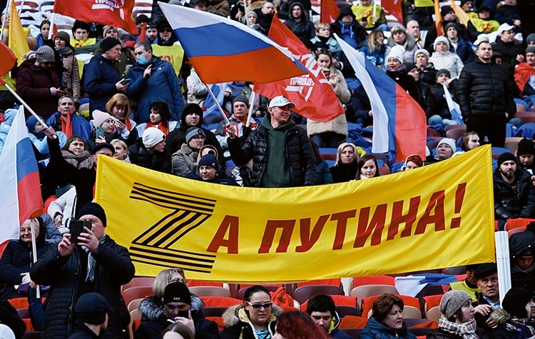 Demonstracja wsparcia dla wojny na Ukrainie.Stadion Łużniki, Moskwa, 18 marca 2022 r.  Na transparencie wykorzystany został znak „Z” – symbol agresji – rozwinięty w hasło: „Za Putina”. Literę „Z” tworzy tzw. wstążka św. Jerzego, symbolizująca zwycięstwo nad III Rzeszą.