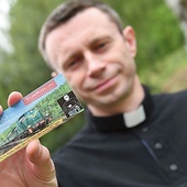 Opiekun duchowy Katolickiego Stowarzyszenia Ojcostwo Powołaniem i wikariusz gubińskiej parafii pw. Trójcy Świętej pokazuje specjalnie wydane bilety na pociąg z Wrocławia do Gubina.