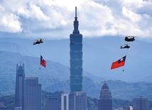 Śmigłowce Chinook w towarzystwie helikopterów bojowych Apache unoszą flagi Tajwanu, przelatując nad centrum Tajpej.