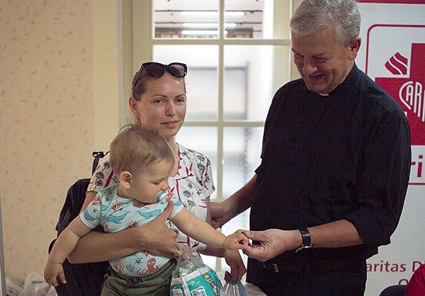 ▲	Ks. Drechsler z podopieczną Caritas i jej synkiem Nazarem.