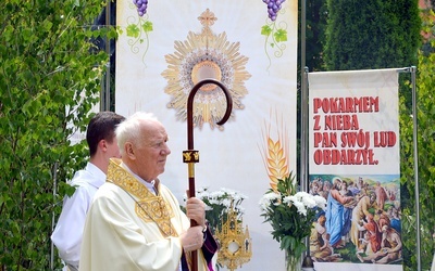 Bp Ignacy Dec na tle jednego z ołtarzy w Nowej Rudzie Słupcu.