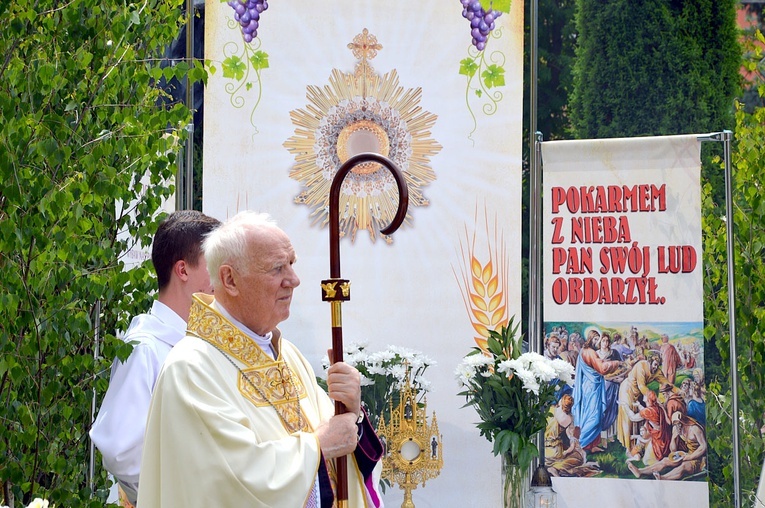 Bp Ignacy Dec na tle jednego z ołtarzy w Nowej Rudzie Słupcu.