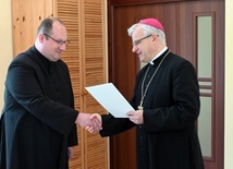 Ks. Krzysztof Iskra odbierający dekret od bp. Marka Mendyka.