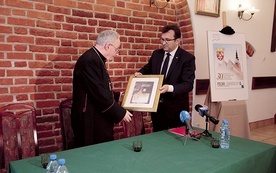 Biskup Jacek Jezierski otrzymuje pamiątkowy znaczek od Wiesława Włodka. 