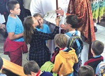 Uczestnicy Oazy Dzieci Bożych rozmawiają  po Mszy św.  z abp. Adrianem.