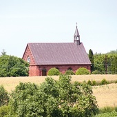 ▲	Kościółek w Karwosiekach widoczny ze wzgórza, na którym znajduje się cmentarz.