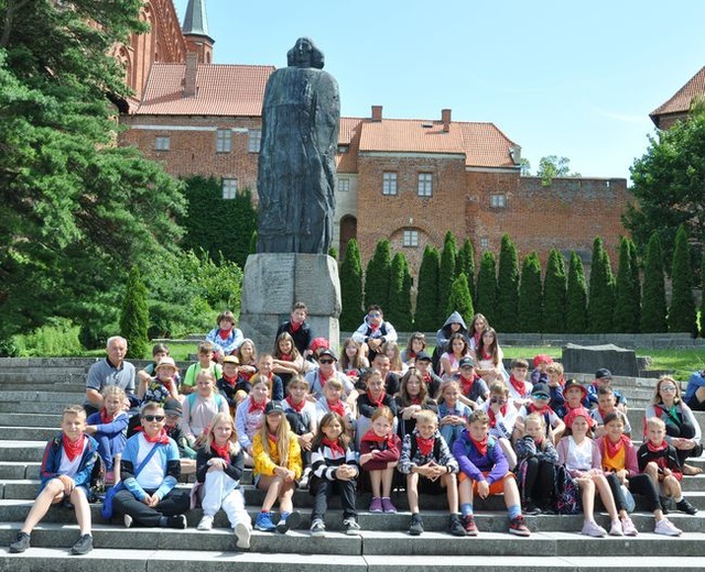 Dzieci przez pomnikiem Kopernika we Fromborku.