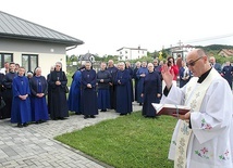 Błogosławieństwo tablicy pamiątkowej, którą umieszczono na ścianie prowadzonego przez siostry przedszkola.