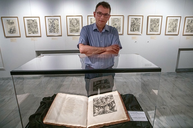 Doktor Piotr Kopszak, dyrektor Muzeum Archidiecezji Warszawskiej, prezentuje księgę z 1511 r. z drzeworytami Dürera.