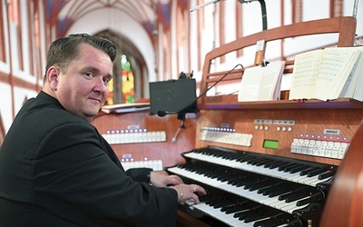 ▼	Ksiądz Wiśniowski  za kontuarem organów  w kościele Mariackim  w Słupsku.