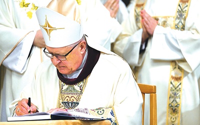 Biskup Edward Dajczak podpisuje uchwały synodalne podczas  Mszy św. kończącej synod.