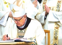 Biskup Edward Dajczak podpisuje uchwały synodalne podczas  Mszy św. kończącej synod.