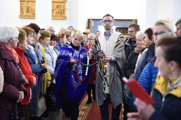 Przedstawiciele róż niosą w darze ołtarza różaniec z barwach kontynentów.