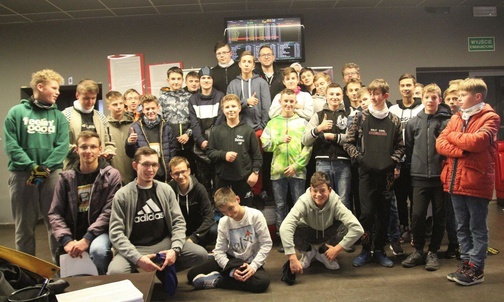 Grupa uczestników warsztatów po rywalizacji na torze kartingowym.