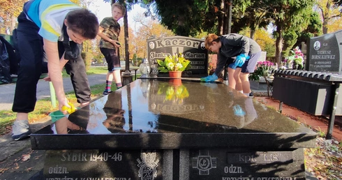 Młodzi kibice sprzątają groby