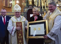 	Ks. proboszcz Szymon Czauderna z medalem Polonia Minor (P), a obok: Iwona Gibas, bp Piotr Greger i Łukasz Korczyk, sołtys miejscowości.